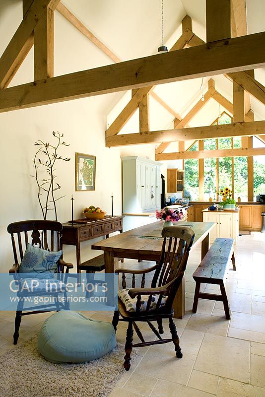 Salle à manger et cuisine à aire ouverte avec poutres en bois et sol en pierre calcaire