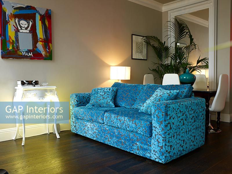 Salon moderne avec canapé en tissu à motif bleu et éclairage ambiant