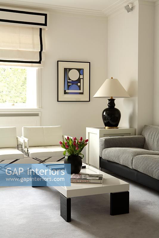 Salon moderne avec fauteuils blancs, canapé gris et table basse