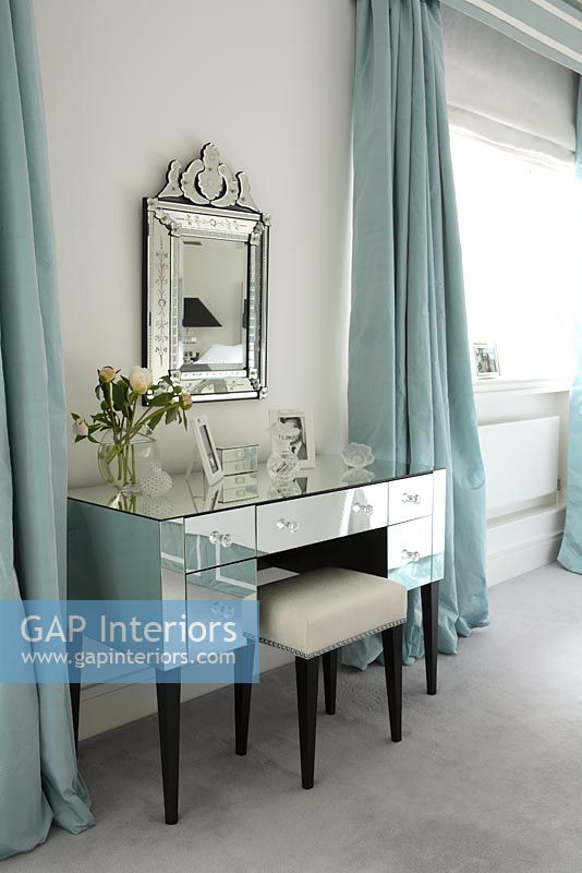 Chambre classique avec coiffeuse miroir et miroir orné et rideaux bleu canard