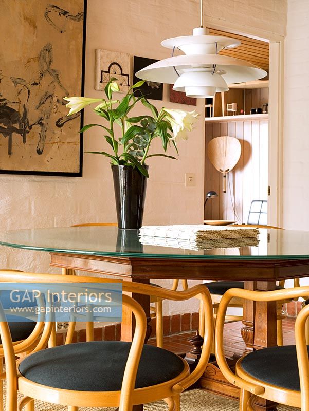 Salle à manger de style scandinave avec table et chaises et table Louis Poulsen lumineuse au-dessus