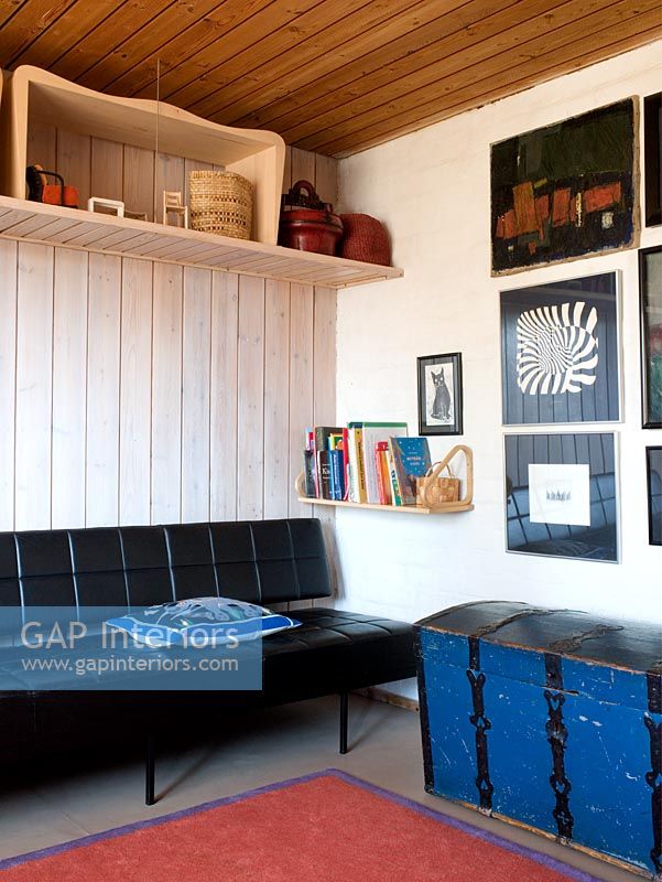 Salon de style scandinave avec canapé en cuir et murs lambrissés