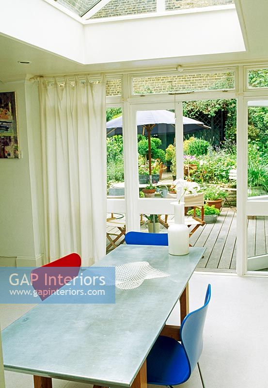 Salle à manger moderne avec vue sur les portes-fenêtres donnant sur le jardin arrière