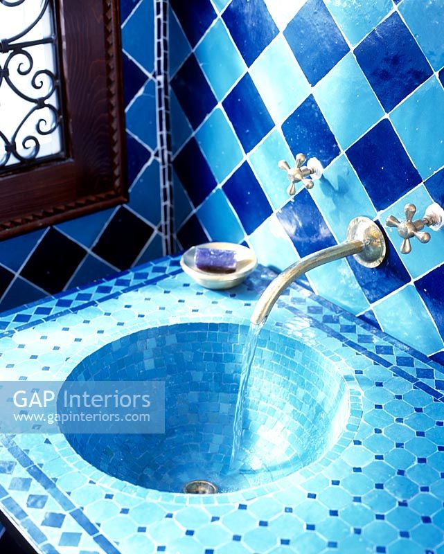 Salle de bain originale avec murs carrelés bleus et lavabo