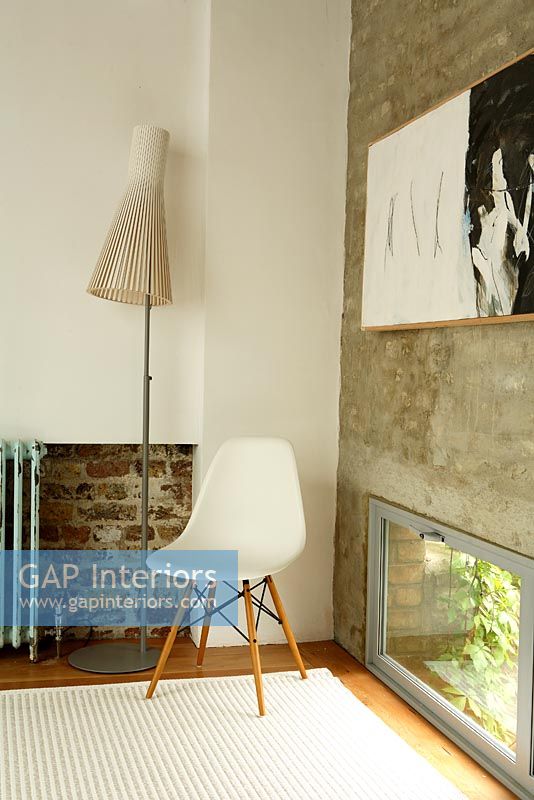 Séjour avec chaise, lampe Seppo Koho et mur de briques apparentes