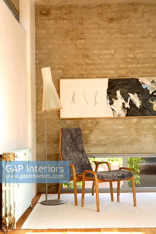Salon contemporain avec lampe Seppo Koho et mur de briques apparentes