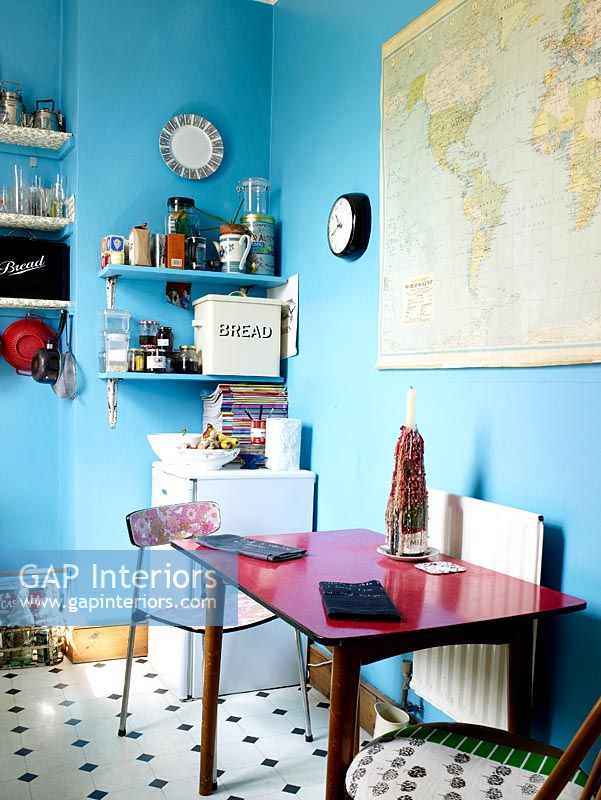 Cuisine-salle à manger originale avec murs peints en bleu et table et chaises