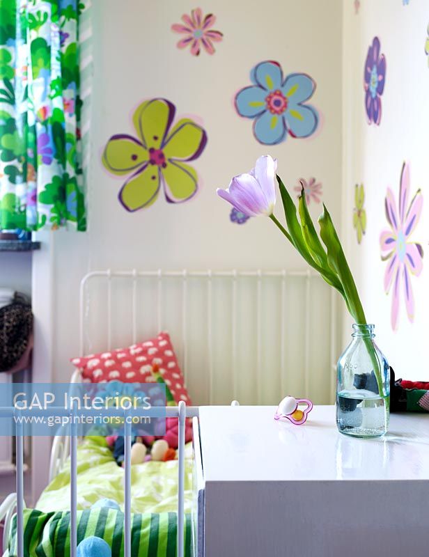 Chambre d'enfants avec des fleurs peintes sur le mur