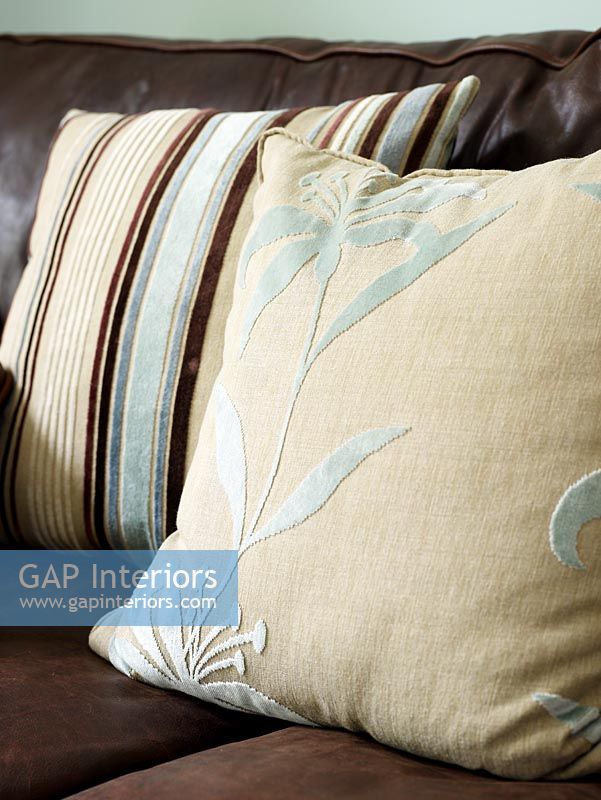 Détail de coussins avec motifs en relief sur canapé en cuir