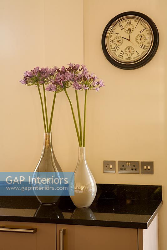 Plan de travail de cuisine avec des fleurs dans des vases