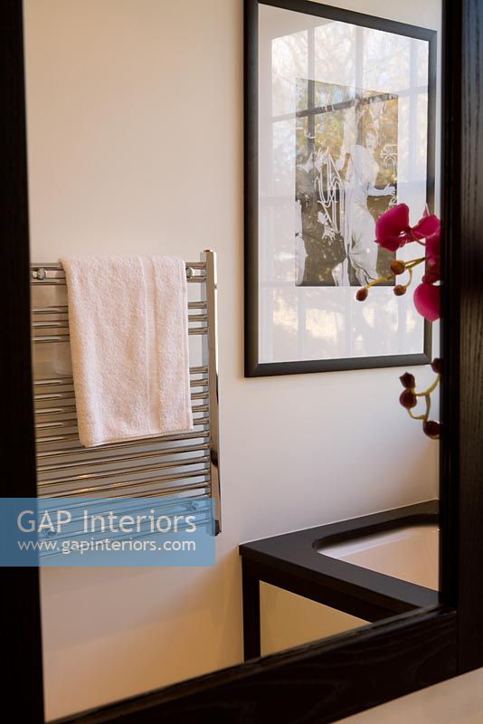 Miroir de salle de bain montrant un radiateur sèche-serviettes en réflexion