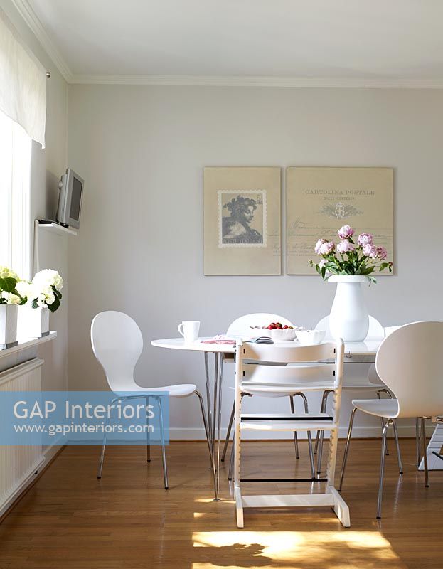 Salle à manger contemporaine blanche avec table Piet Hein et chaises papillon par Arne Jacobsen