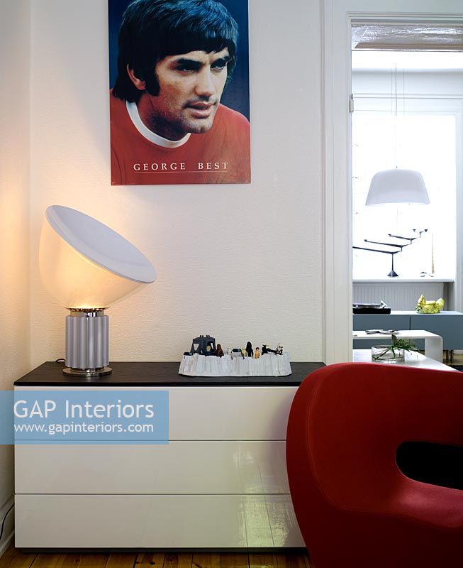 Ensemble de tiroirs blancs avec chaise rouge Ron Arad et affiche George Best