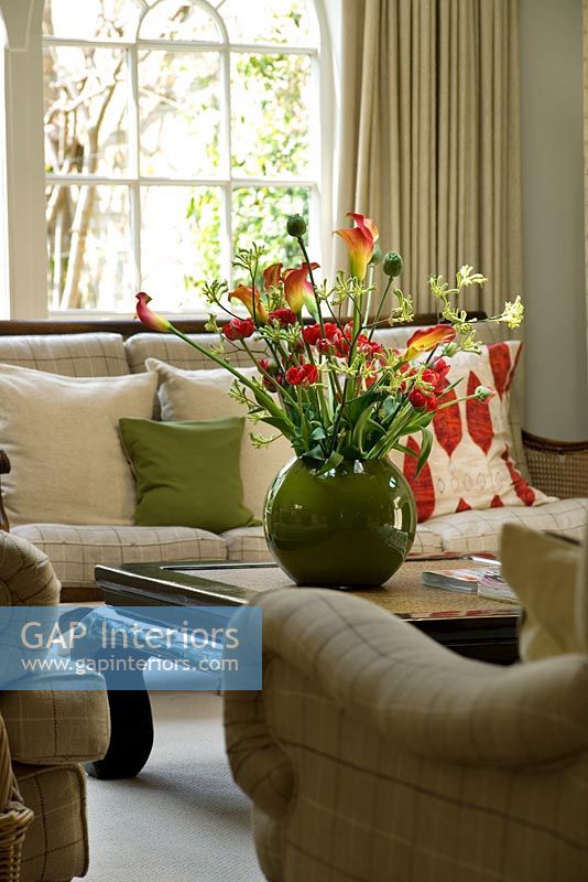 Salon avec belle exposition de fleurs - Lys calla, renoncule, tulipes et patte de kangourou dans un récipient vert