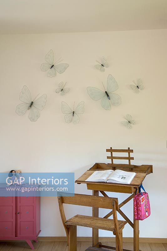 Bureau et chaise en bois avec des papillons sur le mur