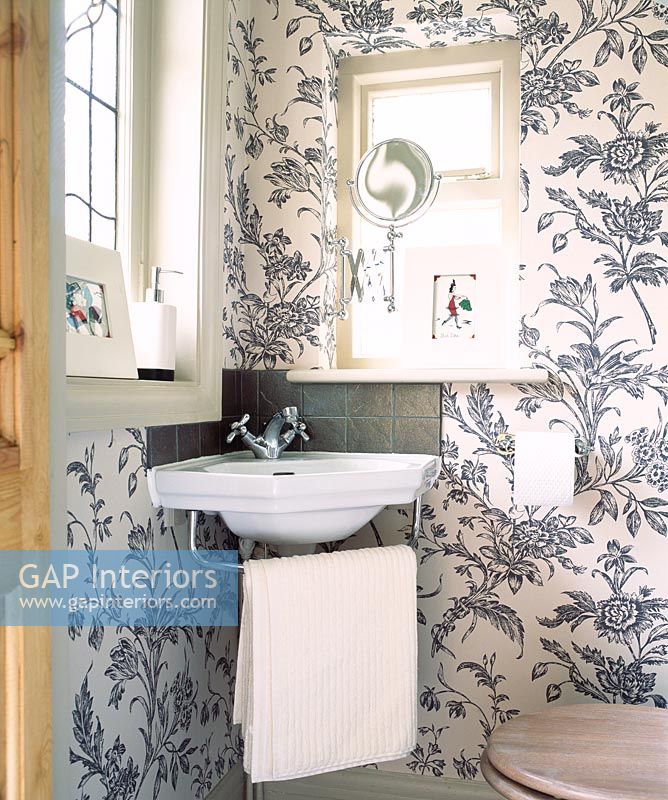 Salle de bain avec papier peint fleuri et lavabo