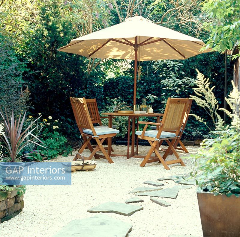 Table et chaises dans un petit jardin avec parasol