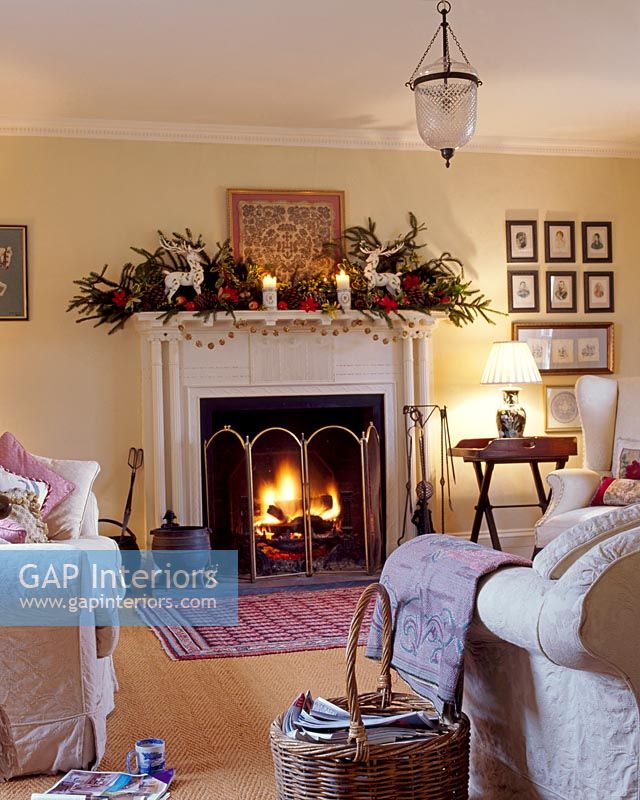 Salon avec cheminée décorée et feu brûlant à Noël