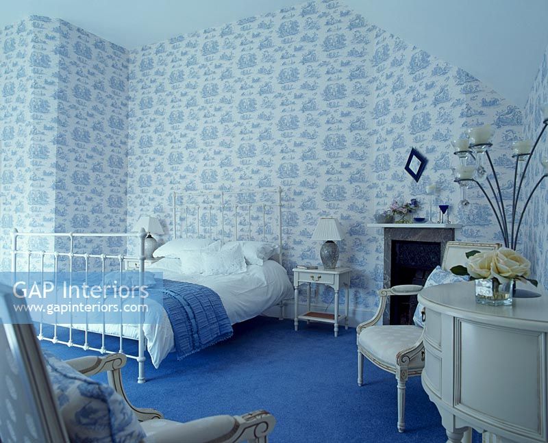 Chambre avec papier peint à motifs et tapis bleu