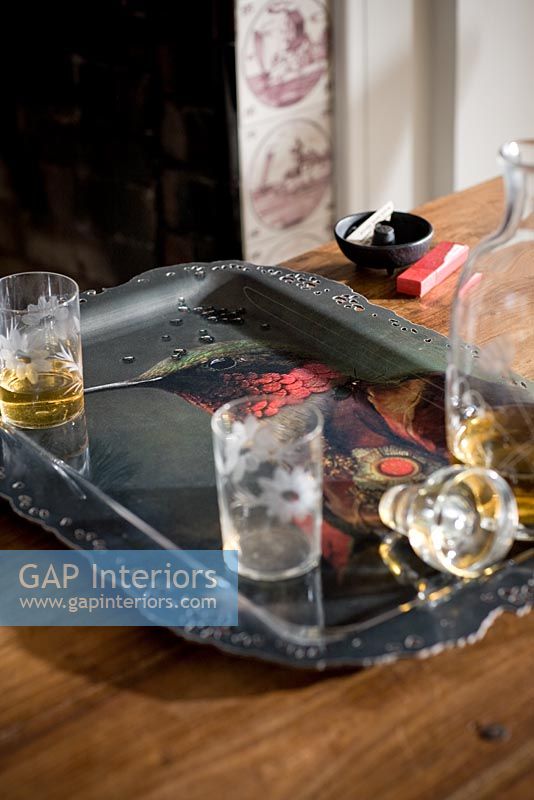 Plateau avec verres et carafe sur la table à côté de la cheminée