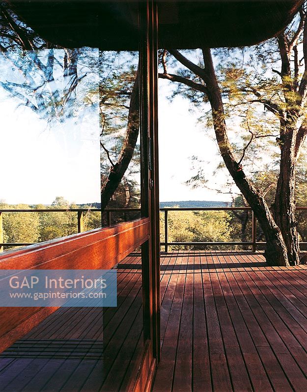 Grand patio en bois reflété dans une porte coulissante en verre