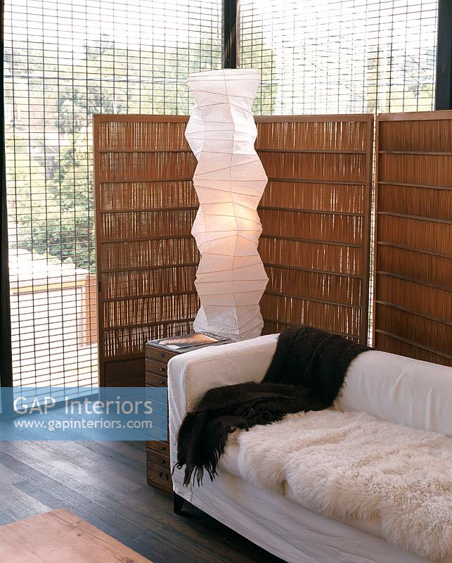 Salon moderne avec lampadaire en papier de riz et cloison en chaume