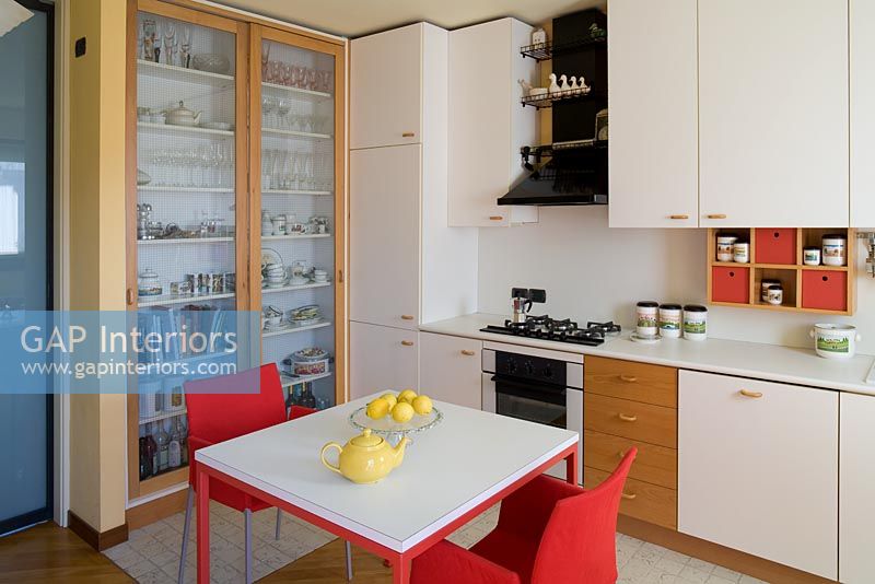 Cuisine moderne avec table blanche et chaises rouges