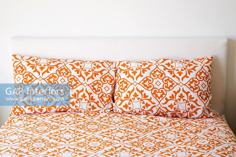 Lit avec draps et oreillers imprimés orange