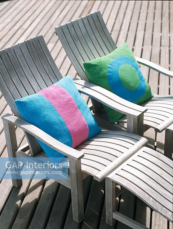 Deux chaises de plage en bois avec des oreillers colorés