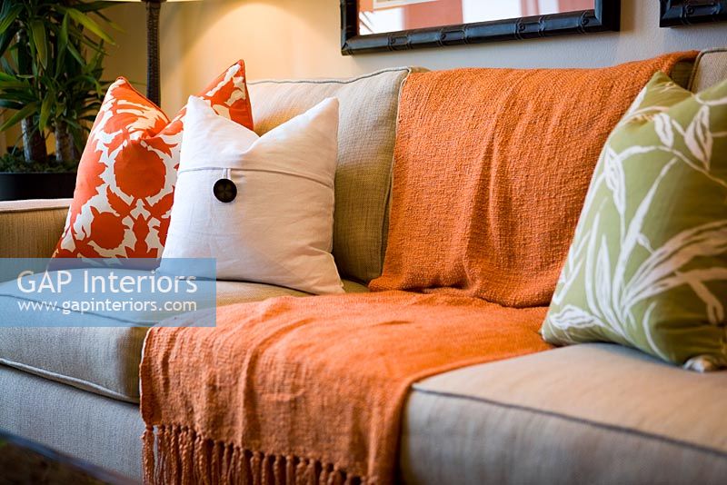 Canapé confortable avec couverture et coussins orange