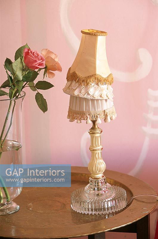 Vue de lampe avec des nuances empilées et des fleurs dans un vase