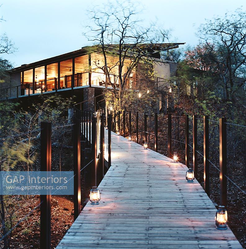 Une façade contemporaine et un chemin en bois avec des lanternes