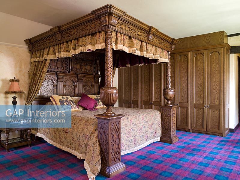 Chambre traditionnelle avec tapis tartan et lit à baldaquin