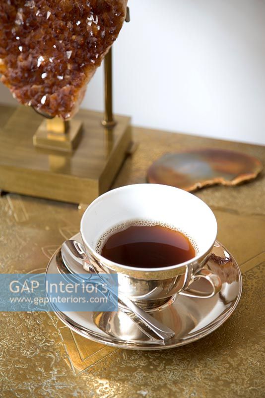 Table d'appoint en or avec tasse à thé et soucoupe