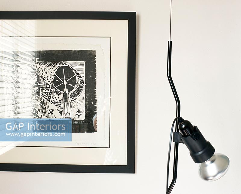 Un dessin contemporain blanc et noir sur le mur et une lampe