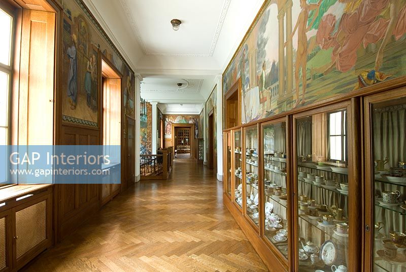 Grand couloir avec peintures murales et vitrines