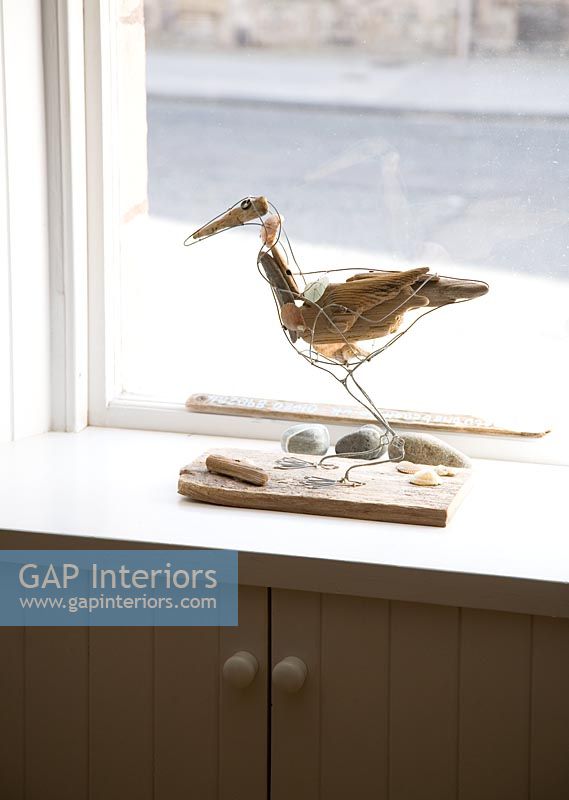 Sculpture d'oiseau de mer sur le rebord de la fenêtre