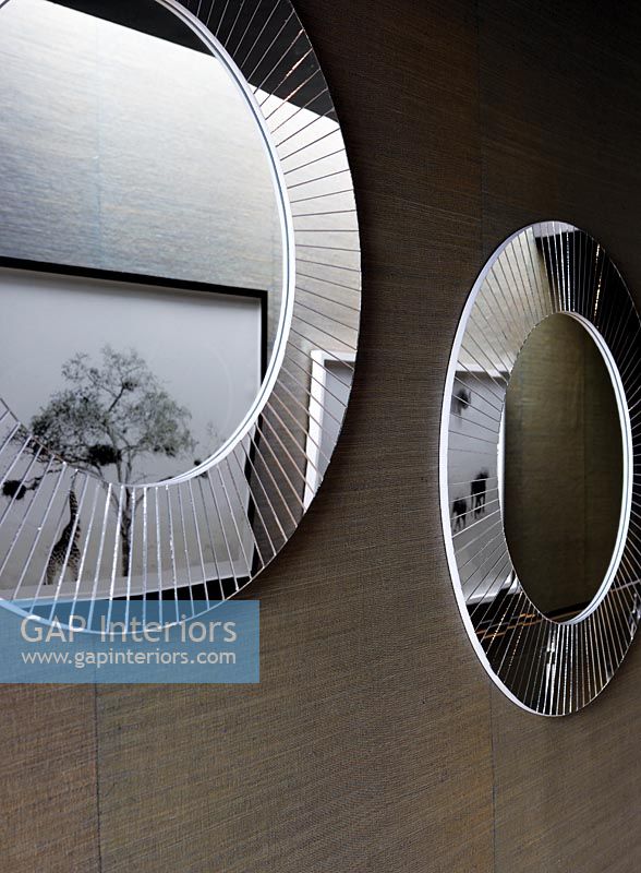 Miroirs ronds et œuvres d'art dans un couloir moderne