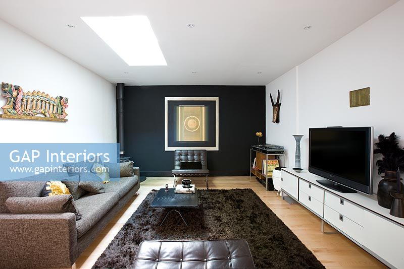 Salon contemporain avec mur noir et tapis marron