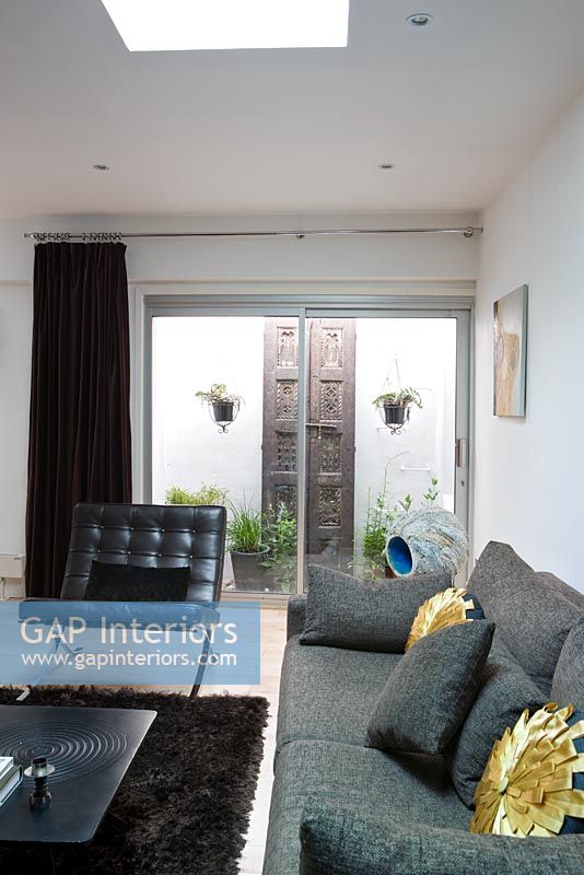 Salon contemporain avec canapé gris et tapis marron