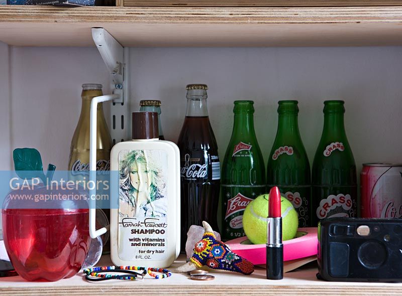 Étagères ouvertes en bois avec des cosmétiques et des bouteilles de boissons