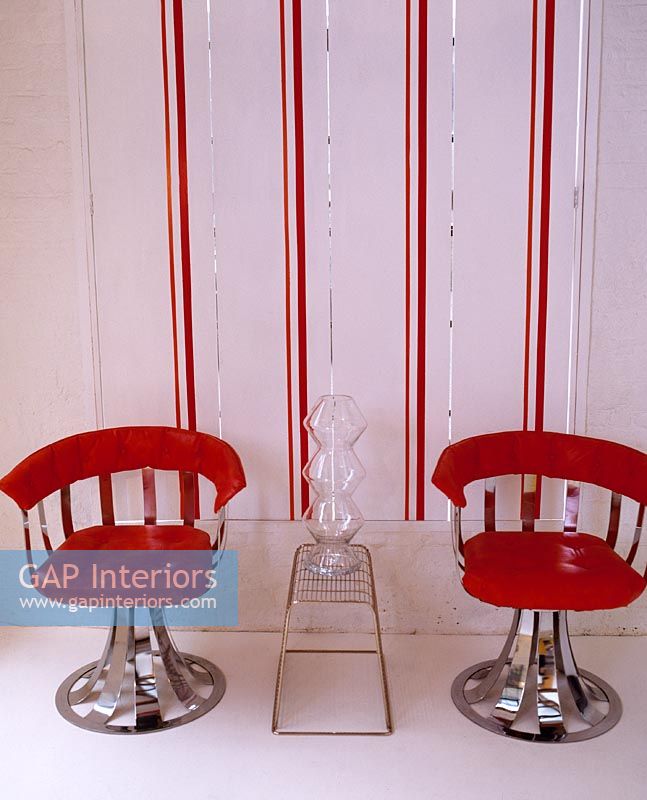 Chaises rétro rouges et papier peint à rayures