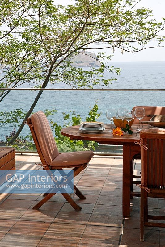 Coin repas contemporain sur terrasse avec vue mer