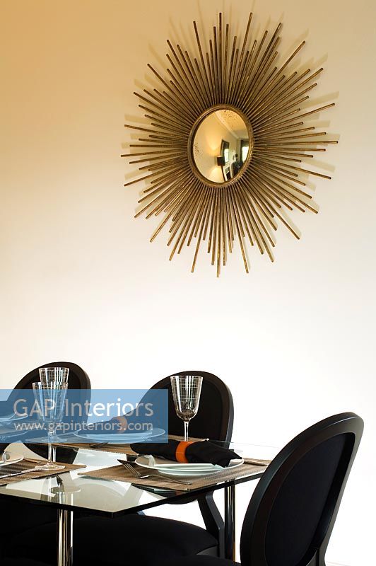 Miroir sunburst doré sur le mur de la salle à manger