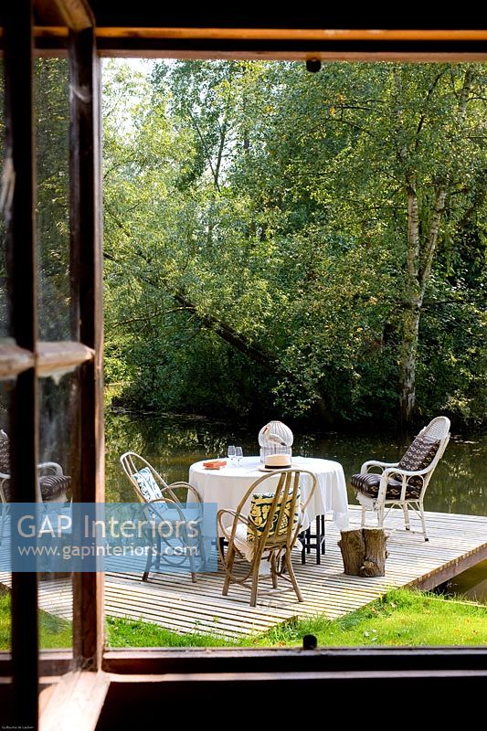 Table et chaises sur la terrasse au bord de l'eau