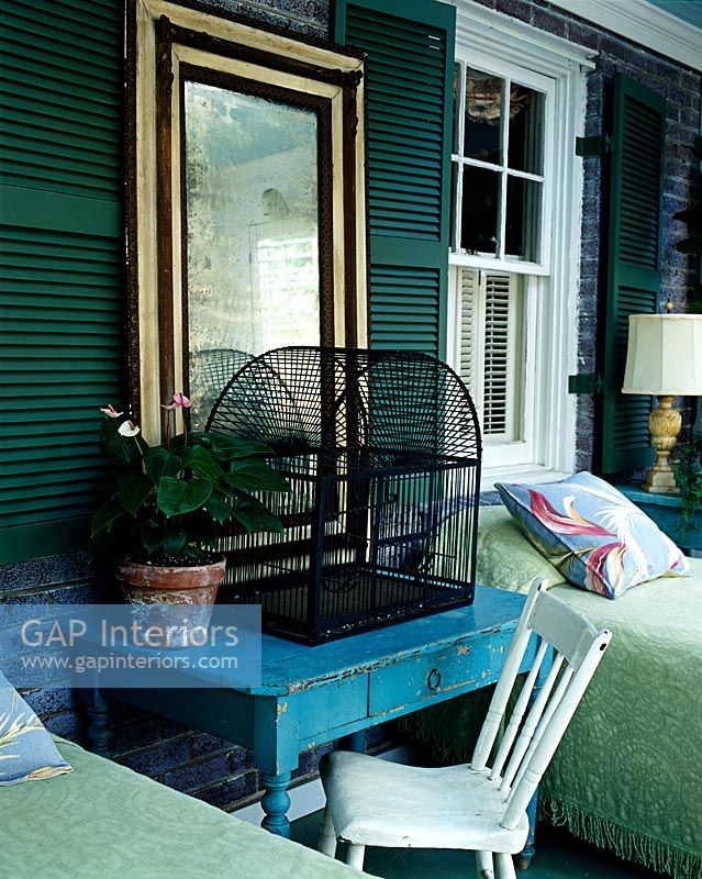 Cage à oiseaux sur une table de chevet dans une chambre de campagne