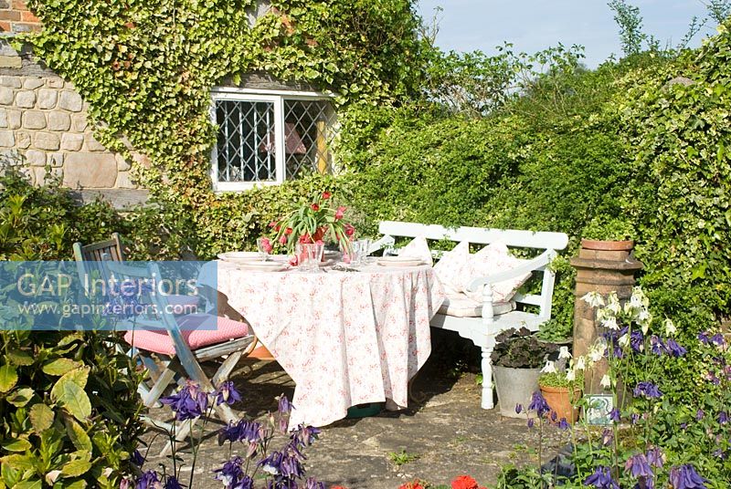 Table et chaises sur terrasse de maison de campagne