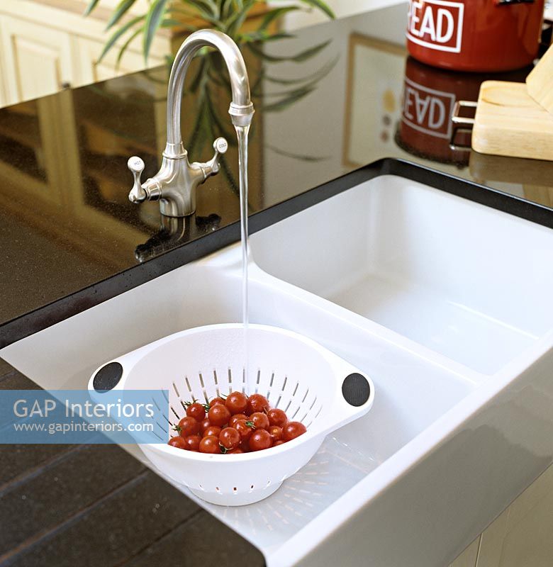 Laver les tomates dans un évier de cuisine moderne