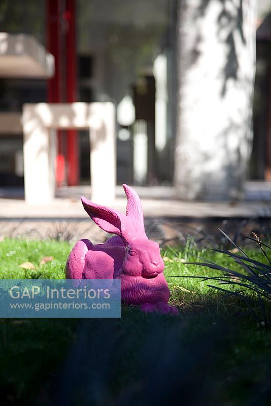 Sculpture de lapin rose dans un jardin moderne