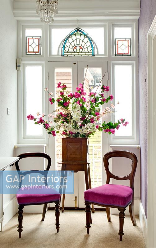 Stand de fleurs et chaises par vitrail
